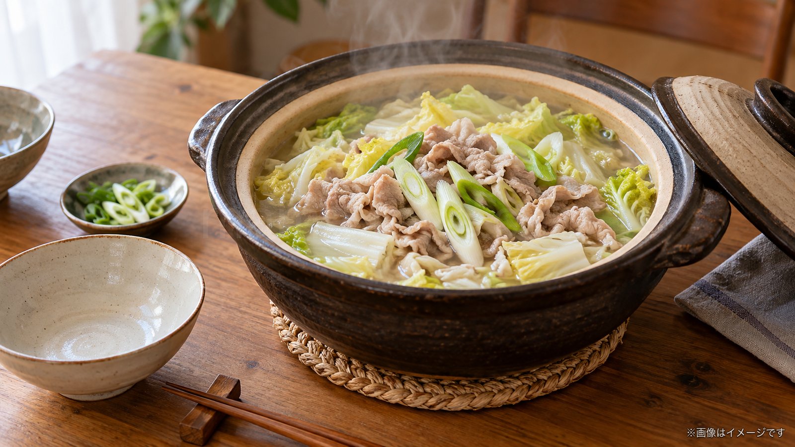 湯気の立つ土鍋の白菜と豚肉の鍋のイメージ
