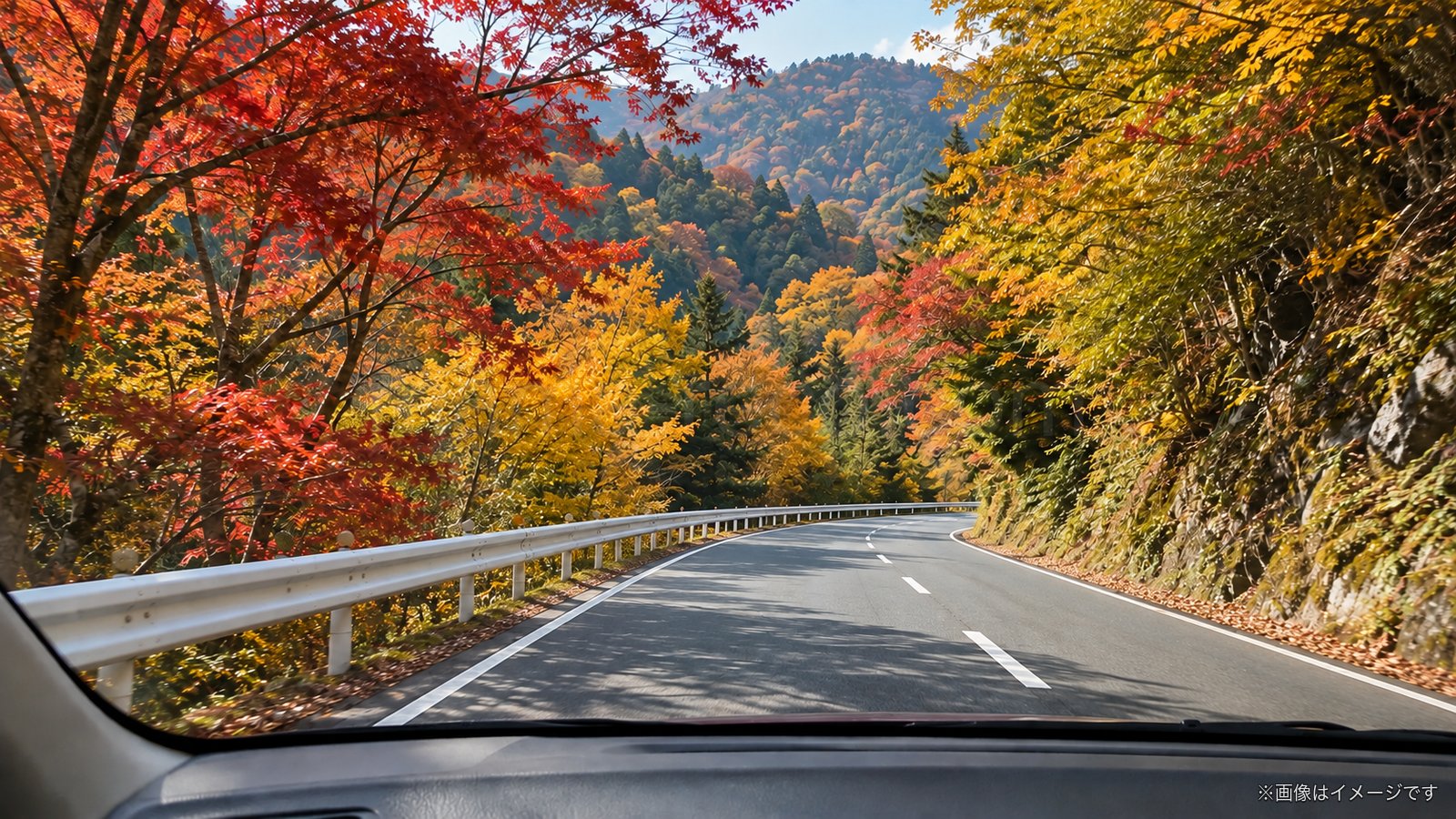 紅葉の山道をドライブする車窓のイメージ